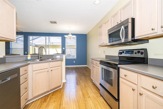 6274 Bristol Channel Way, Orlando, FL 32829 - kitchen featuring light wood-type flooring, visible vents, a sink, stainless steel appliances, and a chandelier
