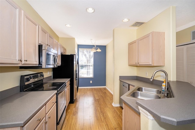 6274 Bristol Channel Way, Orlando, FL 32829 - kitchen featuring visible vents, light wood finished floors, a peninsula, a sink, and stainless steel appliances