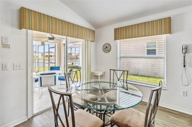 dining space featuring ceiling fan, baseboards, vaulted ceiling, and wood finished floors