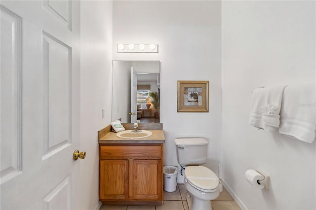 ensuite bathroom with ensuite bathroom, baseboards, toilet, tile patterned floors, and vanity