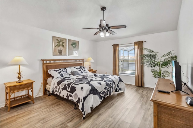 bedroom with baseboards, light wood finished floors, and ceiling fan