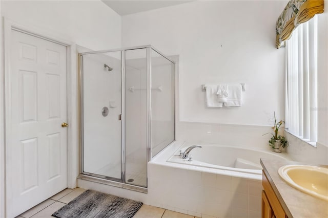 full bath featuring tile patterned floors, vanity, a garden tub, and a shower stall
