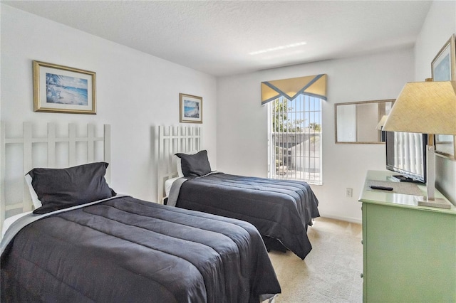 bedroom with light colored carpet and a textured ceiling