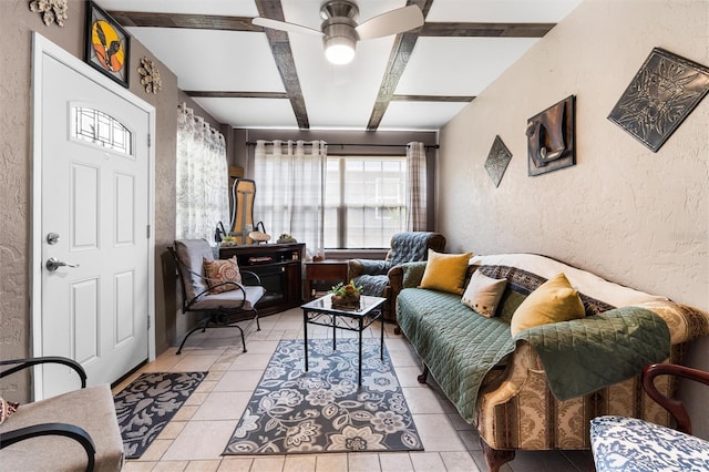 living room featuring light tile patterned floors, beam ceiling, a textured wall, and a ceiling fan