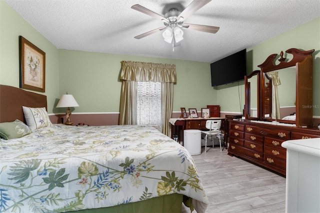 bedroom featuring a ceiling fan, wood finished floors, and a textured ceiling