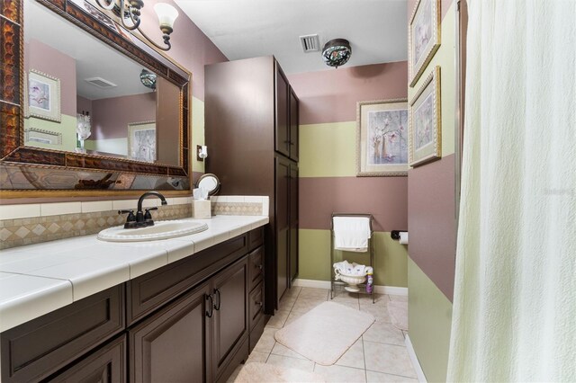 bathroom with visible vents, tile patterned flooring, vanity, and tasteful backsplash