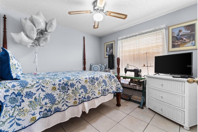 bedroom featuring a ceiling fan, light tile patterned flooring, and a textured ceiling