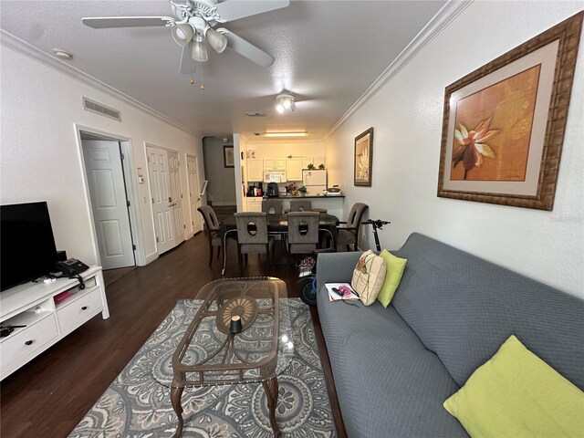 2964 Lucayan Harbour Cir Unit 106, Kissimmee, FL 34746 - living room featuring visible vents, a ceiling fan, dark wood-style flooring, and crown molding