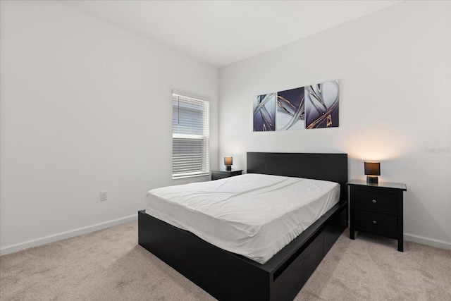 bedroom featuring light colored carpet and baseboards