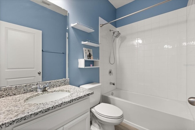 bathroom featuring visible vents, toilet, wood finished floors, vanity, and shower / bath combination