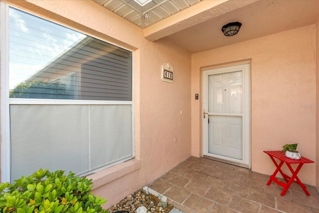 doorway to property featuring stucco siding