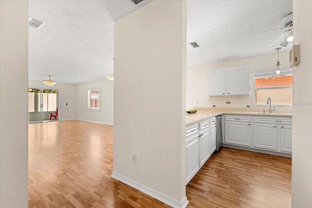 kitchen with open floor plan, visible vents, a sink, and ceiling fan