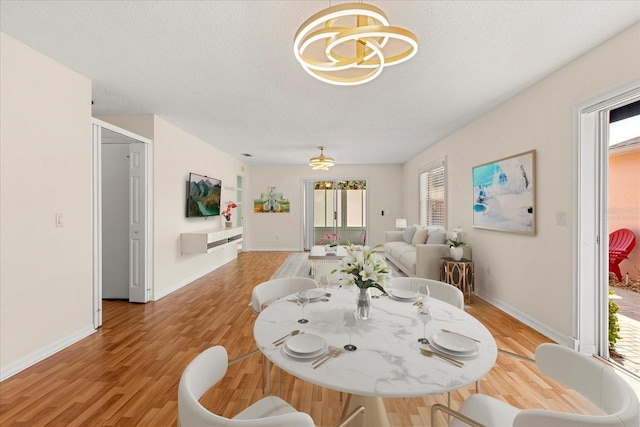 dining room with a wealth of natural light, light wood-style floors, and a textured ceiling