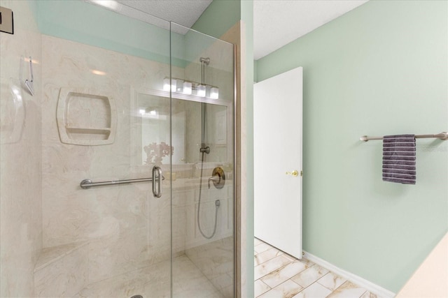 bathroom with a stall shower and baseboards