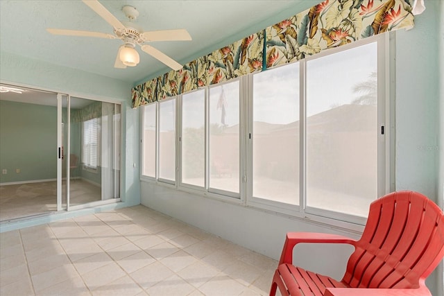 sunroom with tile patterned floors and ceiling fan