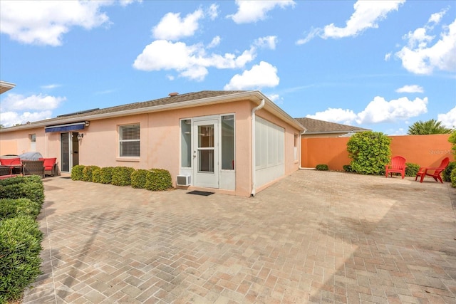 back of house featuring stucco siding, driveway, fence, and a patio area