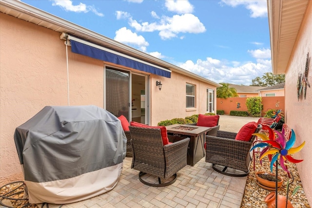 view of patio featuring a grill, an outdoor fire pit, and fence