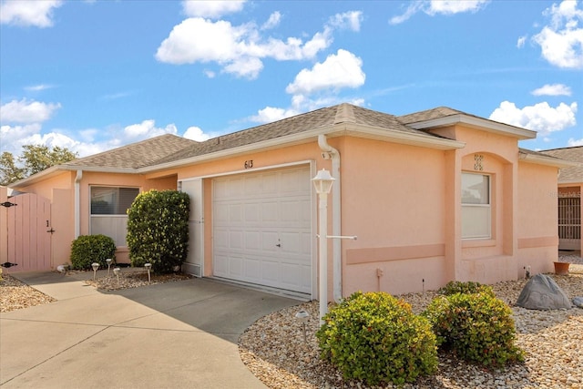 view of front of home with driveway, a gate, a garage, and stucco siding