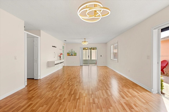 613 Nuevo Leon Ln, The Villages, FL 32159 - unfurnished living room with a chandelier and light wood-type flooring