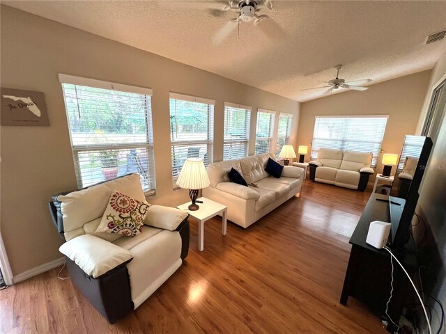 4638 River Ridge Drive, Leesburg, FL 34748 - living room with a textured ceiling, wood finished floors, a ceiling fan, and vaulted ceiling