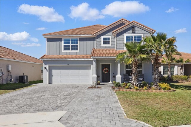 1158 Oak Bluff Dr, Davenport, FL 33837 - view of front of house with a tile roof, decorative driveway, an attached garage, and a front lawn