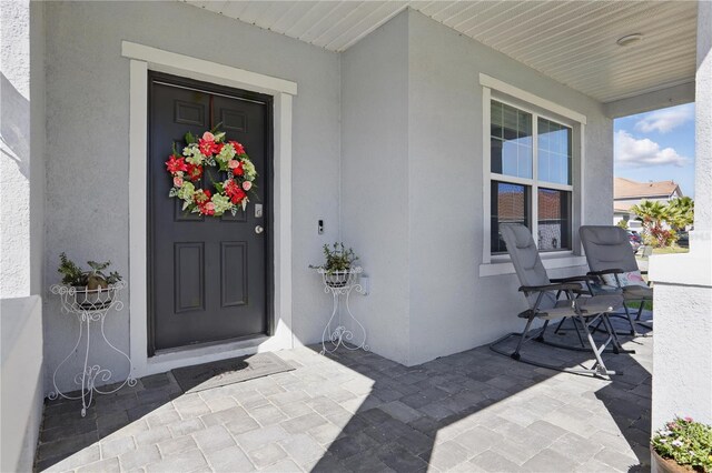 1158 Oak Bluff Dr, Davenport, FL 33837 - property entrance with stucco siding and a porch