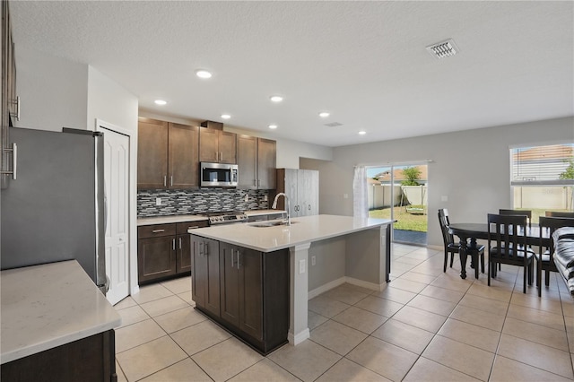 1158 Oak Bluff Dr, Davenport, FL 33837 - kitchen featuring stainless steel appliances, light countertops, light tile patterned floors, tasteful backsplash, and recessed lighting