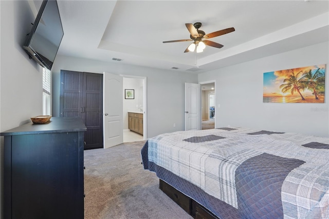 1158 Oak Bluff Dr, Davenport, FL 33837 - bedroom with light carpet, a raised ceiling, ceiling fan, and ensuite bath