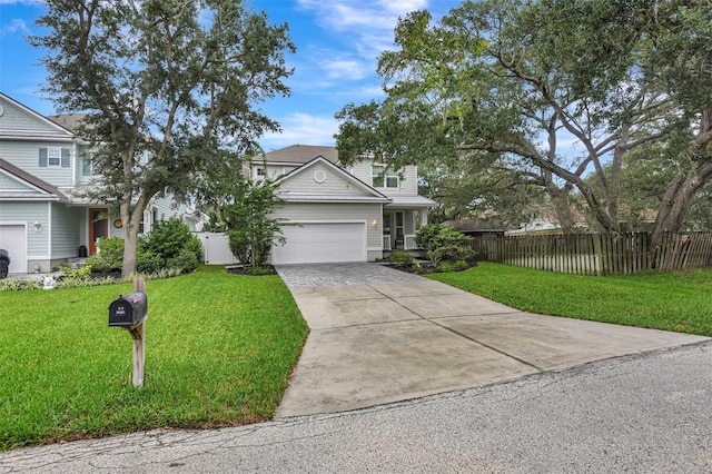 view of front of house with driveway, a garage, fence, and a front yard
