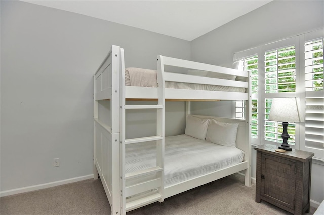 unfurnished bedroom featuring carpet flooring, baseboards, and multiple windows
