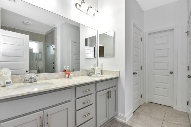 full bath featuring double vanity, a sink, a stall shower, and tile patterned floors