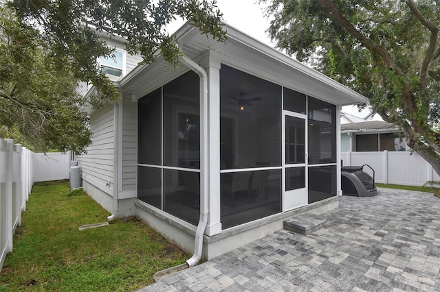 view of side of home featuring a fenced backyard, a sunroom, and a yard