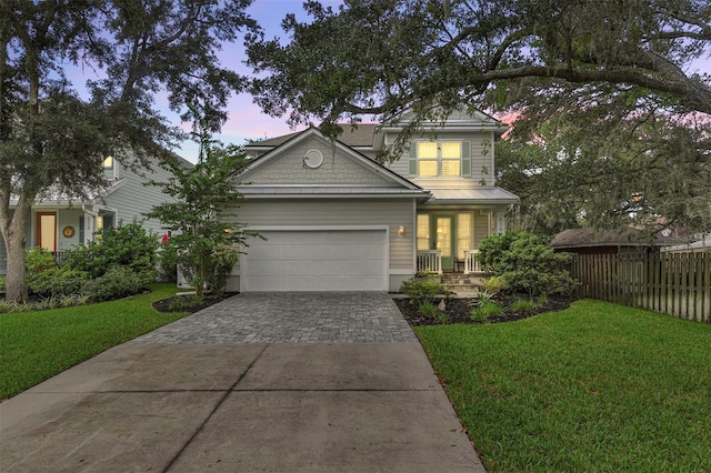 view of front of property featuring a front lawn, driveway, fence, and a garage