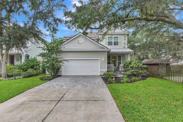 craftsman-style house with a front yard, decorative driveway, fence, and a garage