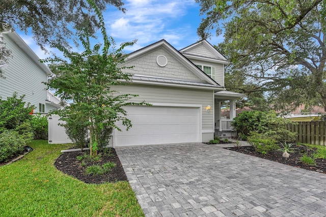 view of front of house featuring driveway, a garage, a front lawn, and fence