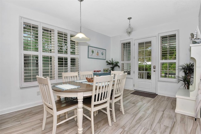 dining area with baseboards and light wood-type flooring