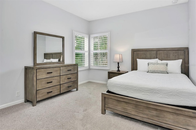 bedroom featuring baseboards and light carpet