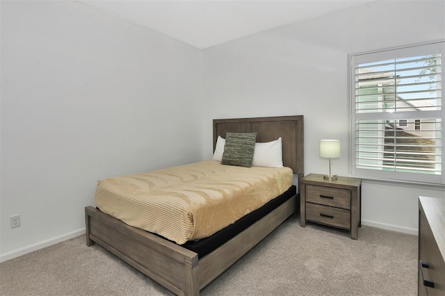 bedroom with light carpet and baseboards