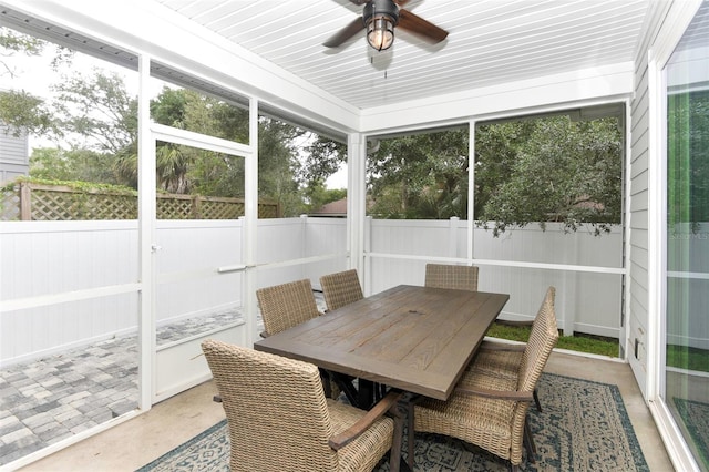 sunroom with outdoor dining space and a ceiling fan