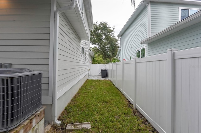 view of yard featuring a fenced backyard and central AC