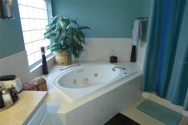 full bath featuring a tub with jets, tile patterned flooring, and a wealth of natural light