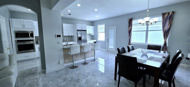 4730 Capital Blvd, Saint Cloud, FL 34769 - dining area with marble finish floor, baseboards, a notable chandelier, and arched walkways