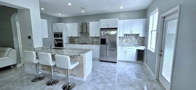 4730 Capital Blvd, Saint Cloud, FL 34769 - kitchen featuring wall chimney exhaust hood, white cabinets, a sink, and stainless steel appliances