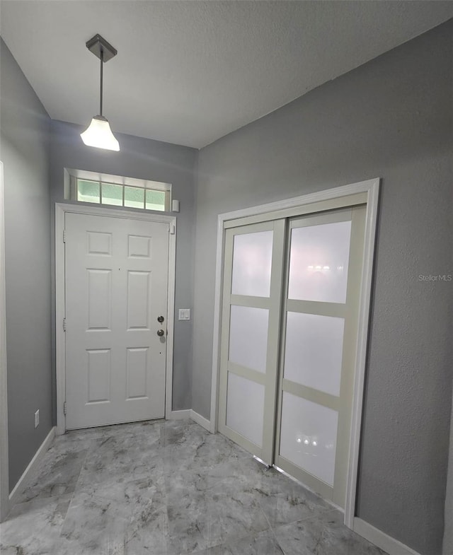 4730 Capital Blvd, Saint Cloud, FL 34769 - foyer featuring marble finish floor, baseboards, and a textured ceiling