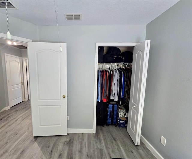 4730 Capital Blvd, Saint Cloud, FL 34769 - bedroom with baseboards, visible vents, a closet, and wood finished floors