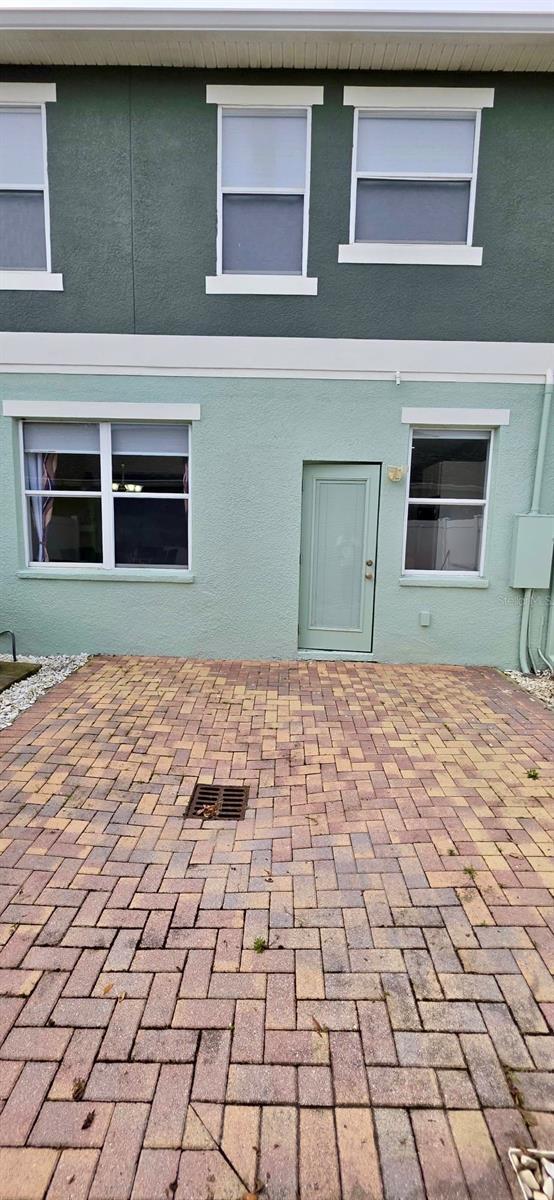 4730 Capital Blvd, Saint Cloud, FL 34769 - rear view of property with stucco siding and a patio