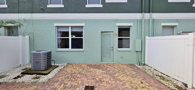 4730 Capital Blvd, Saint Cloud, FL 34769 - entrance to property with stucco siding, fence, central AC, and a patio area