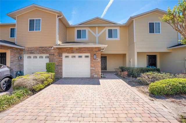 10124 Shadow Leaf Ct, Orlando, FL 32825 - view of property featuring stone siding, stucco siding, decorative driveway, and a garage