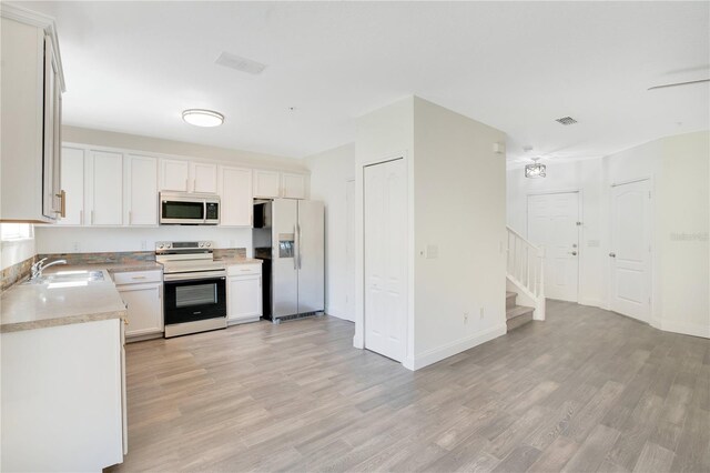 10124 Shadow Leaf Ct, Orlando, FL 32825 - kitchen with light countertops, a sink, stainless steel appliances, visible vents, and light wood-style floors