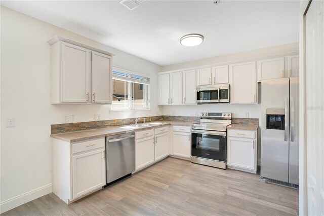 10124 Shadow Leaf Ct, Orlando, FL 32825 - kitchen with visible vents, baseboards, appliances with stainless steel finishes, white cabinetry, and light wood-style floors